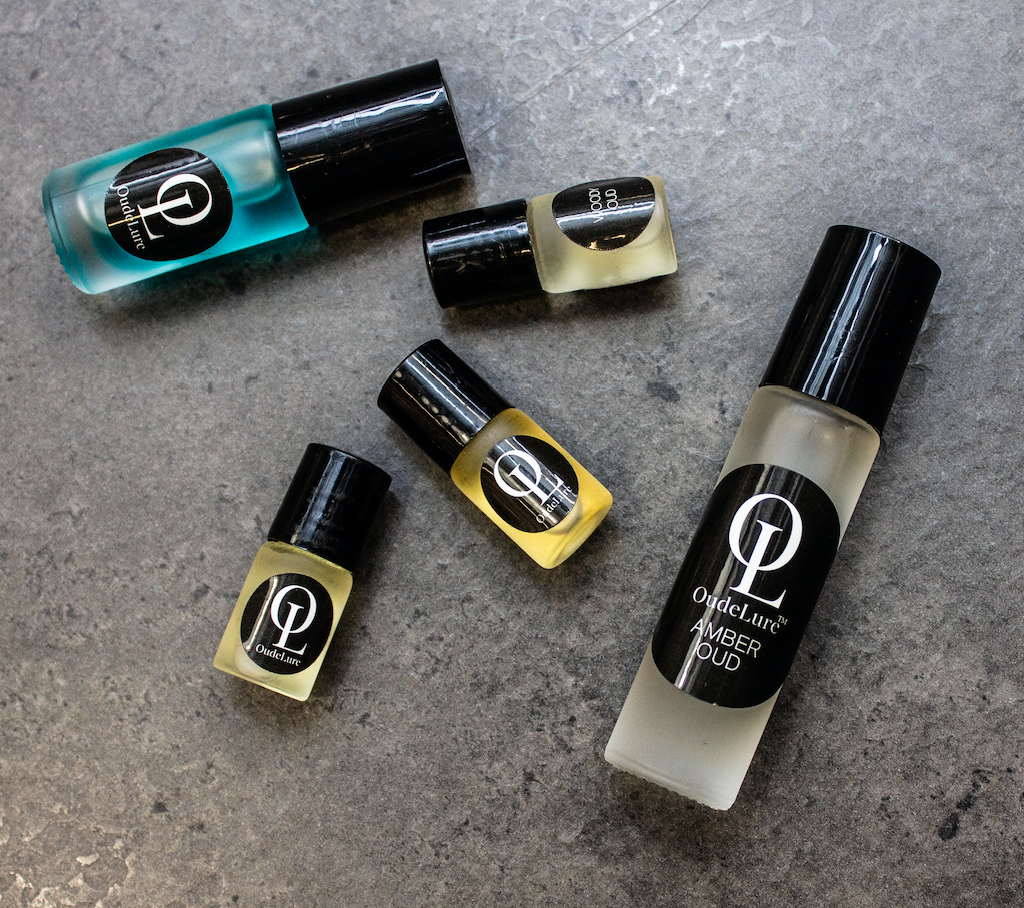Collection of Oudelure bottles on a textured surface